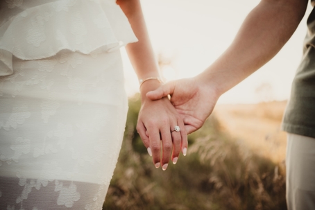 engaged couple holding hands and showing off ring