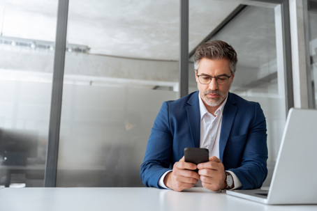 man checking phone while working in an office